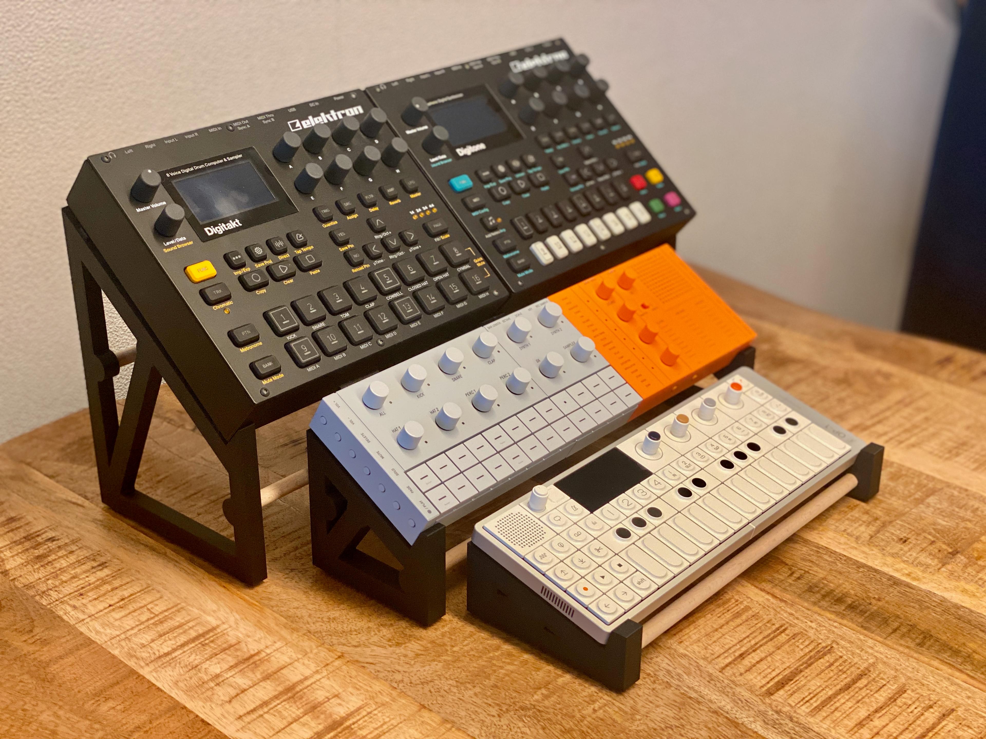 A three tier stand with digitakt, digitone, seqtrak, and op-1 field on a wooden desk